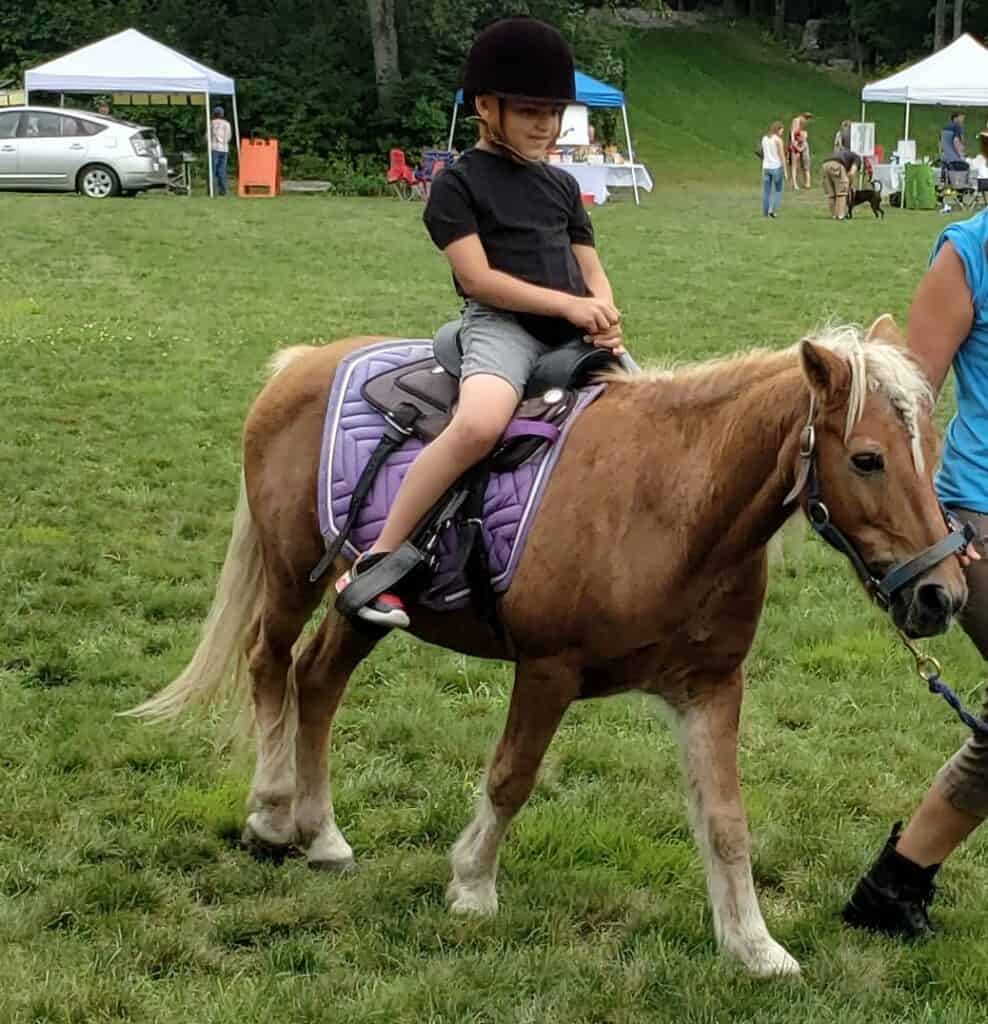A child riding a pony.