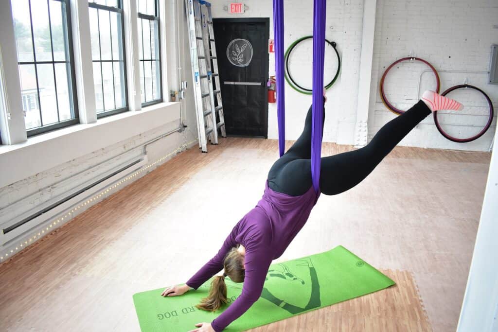 A woman taking an aerial yoga class at Earth and Aerial Yoga.
