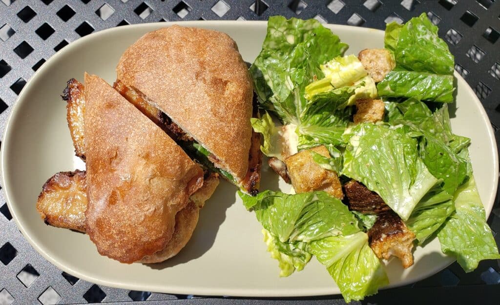 A porchetta sandwich and side salad.